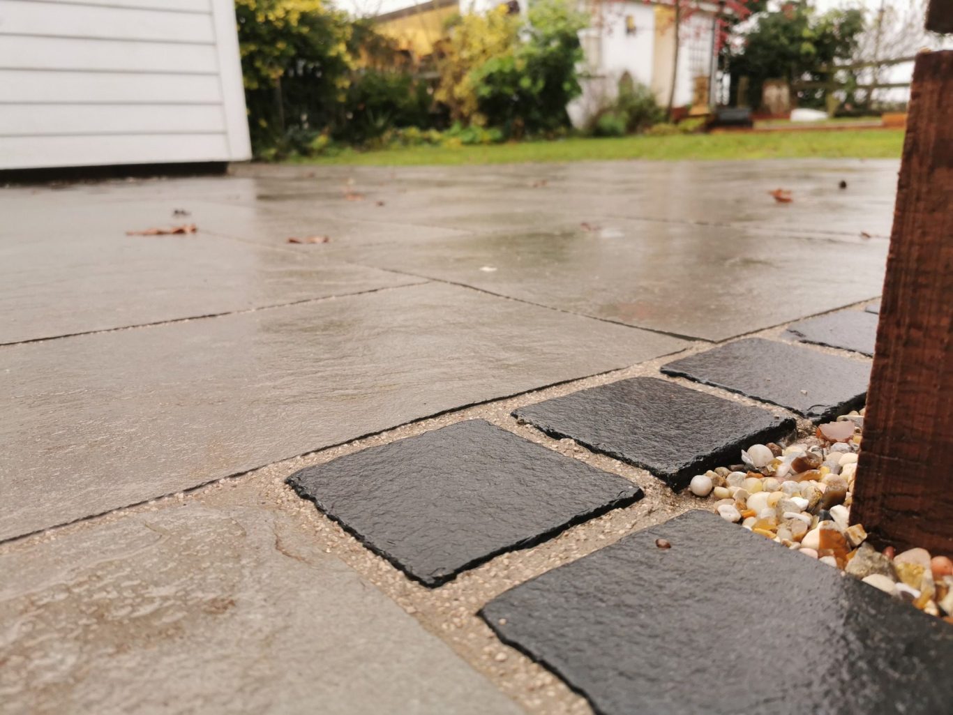 Limestone patio with black limestone cobbles built by Nu-Bourne Landscapes in Saffron Walden